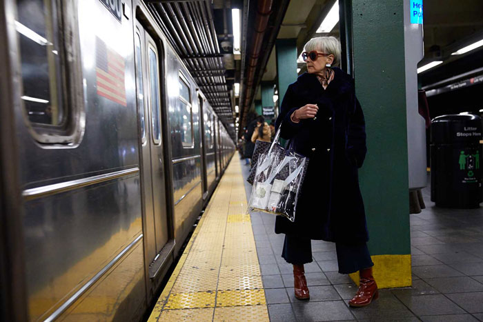 Accidental Icon on Train Station Wearing Long Coat | 40plusstyle.com