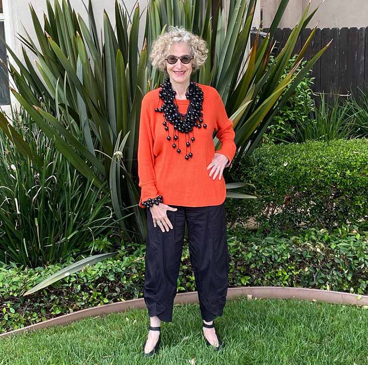 Dayle wears an orange and black outfit | 40plusstyle.com