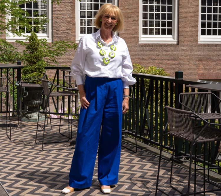 Greetje wears a white blouse and statement necklace | 40plusstyle.com